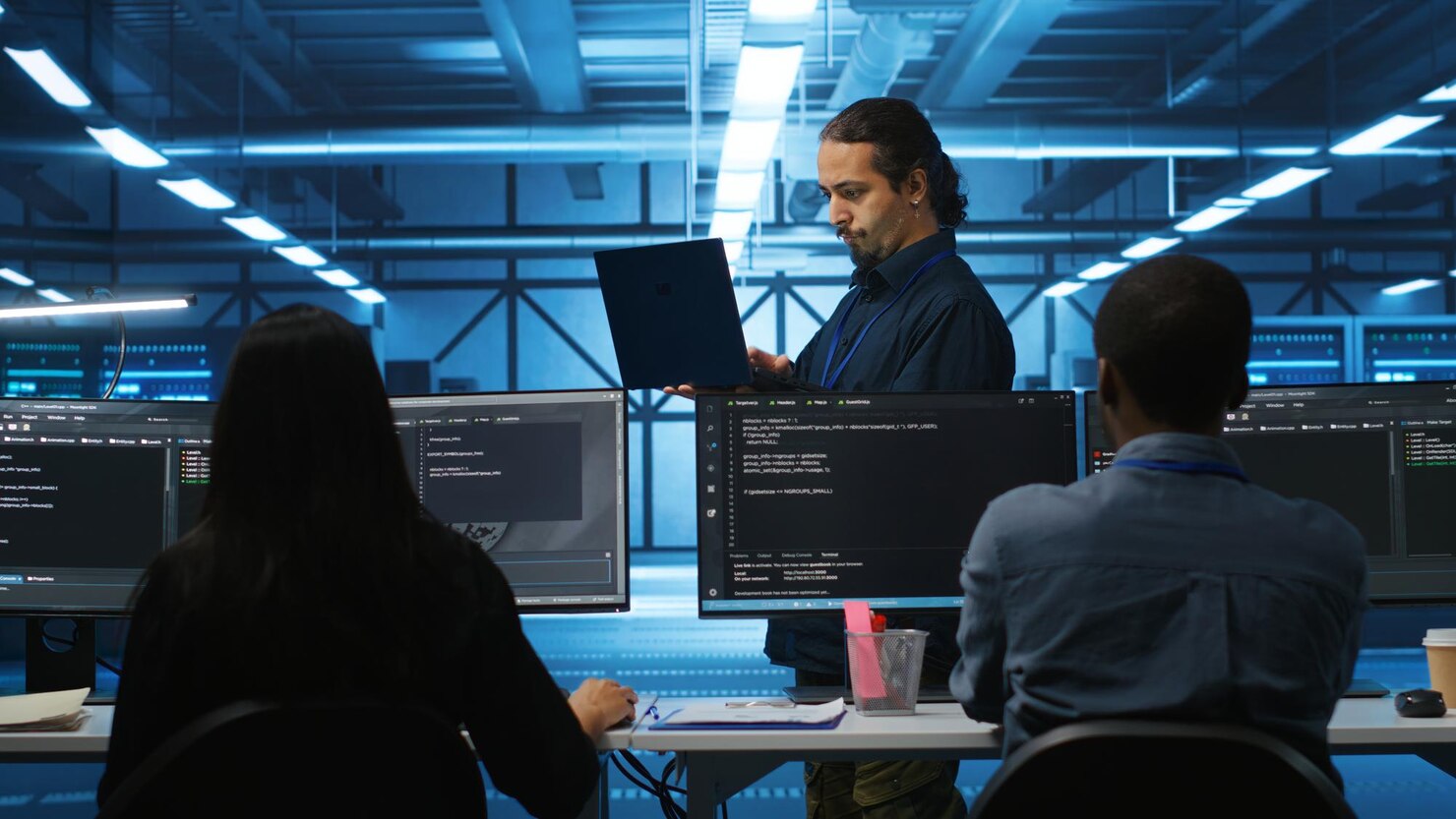 manager-reading-paperwork-laptop-verifying-infrastructure-documents